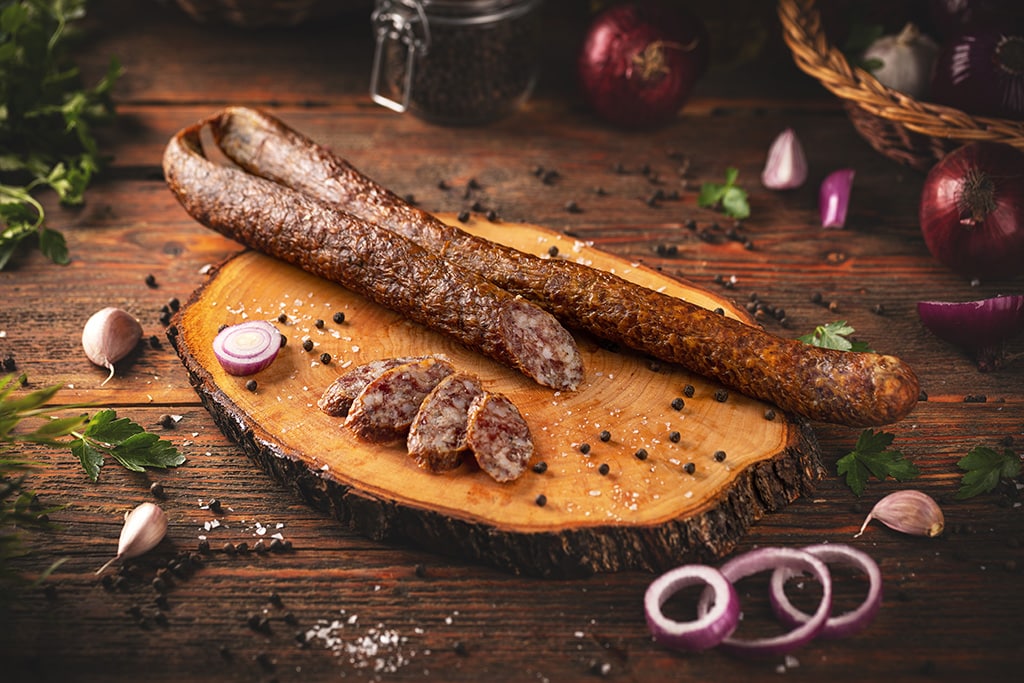 Smoked sausage on a wooden rustic table with spices
