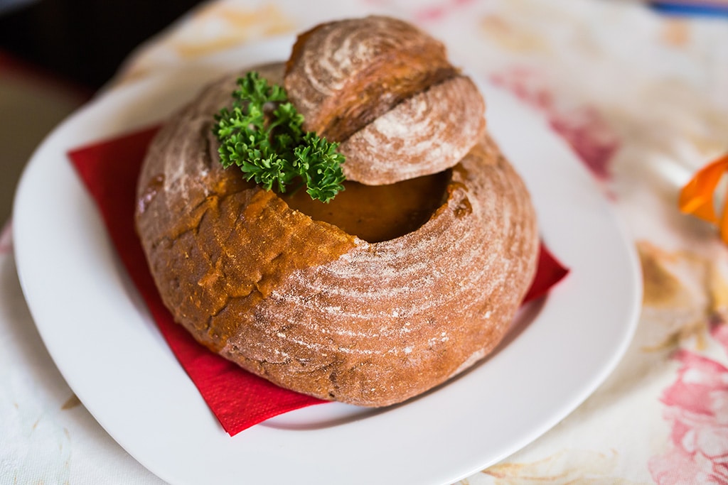 Hungarian food with beef, potato and meat sausage, served in a bread bowl.