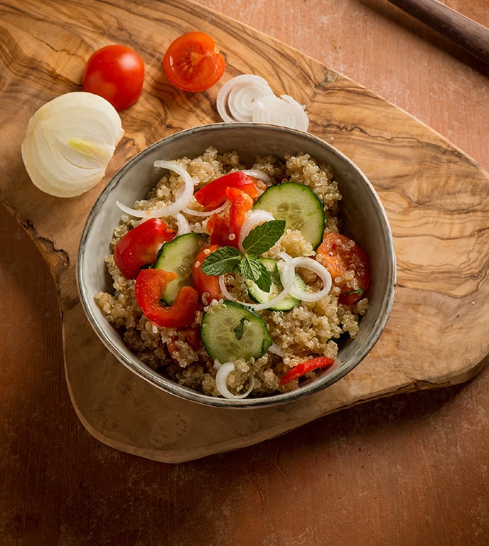 greek quinoa salad with tomatoes pepper cucumber onion and mint leaf